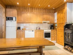 eine Küche mit Holzschränken und einem Holztisch in der Unterkunft Holiday Home Hirvas levi 4 by Interhome in Levi