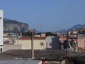 a view of roofs of buildings with mountains in the background at casaLiuccia in Mondello +7 photos