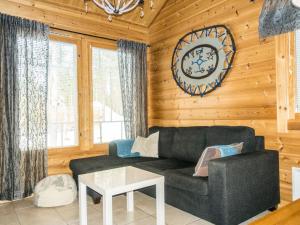 ein Wohnzimmer mit einer Couch und einer Uhr an der Wand in der Unterkunft Holiday Home Hirvas levi 2 by Interhome in Levi + 7 Fotos