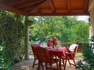 a table with a red table cloth and chairs on a patio at Holiday Home Ljudevit by Interhome in Dobrinj