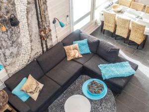 ein Wohnzimmer mit einer schwarzen Couch und einem Tisch in der Unterkunft Holiday Home Rapsakka by Interhome in Levi
