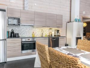 a kitchen with stainless steel appliances and a table with chairs at Holiday Home Rapsakka by Interhome in Levi