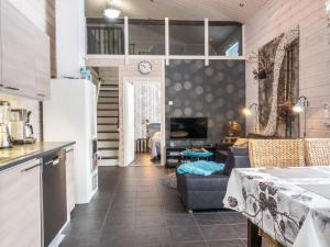 eine Küche und ein Wohnzimmer mit Sofa und Tisch in der Unterkunft Holiday Home Rapsakka by Interhome in Levi