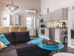 a living room with a couch and a kitchen at Holiday Home Rapsakka by Interhome in Levi