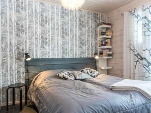 ein Schlafzimmer mit einem Bett mit einer blauen Bettdecke in der Unterkunft Holiday Home Rapsakka by Interhome in Levi + 11 Fotos