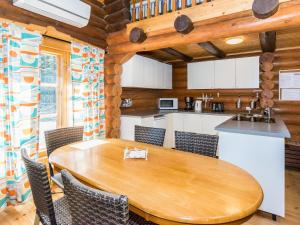 una cucina e una sala da pranzo con tavolo e sedie in legno di Holiday Home Villa irene by Interhome a Parikka