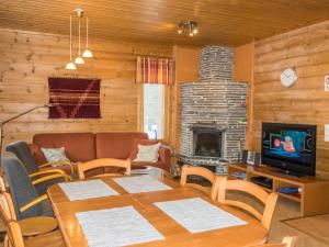 a living room with a table and a fireplace at Holiday Home Nuottiukko by Interhome in Levi