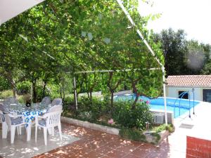 a patio with a table and chairs next to a pool at Apartment Stella by Interhome in Bribir