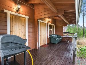 a porch of a wooden house with a grill at Holiday Home Mäntymäki by Interhome in Kelkala