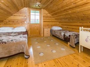 a log cabin bedroom with two beds and a window at Holiday Home Metsämökki by Interhome in Barkarböle