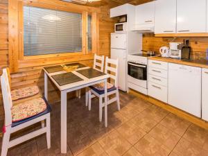 a kitchen with a table and chairs in a cabin at Holiday Home Metsämökki by Interhome in Barkarböle