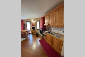 a kitchen with wooden cabinets and a dining room at Appartamento per 5 Abetone, vista Piste. in Abetone