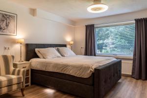 Un dormitorio con una cama grande y una ventana en B&B Eikendreef, en Haelen
