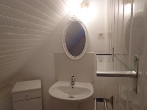 a white bathroom with a sink and a mirror at Les fleurs du Mont in Céaux