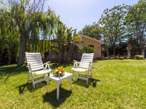 three chairs and a table in a yard at Villa Orchidea by Interhome in Arenella