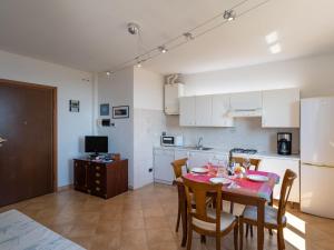 eine Küche und ein Esszimmer mit einem Tisch und Stühlen in der Unterkunft Apartment Le Margherite - SLR261 by Interhome in Costarainera