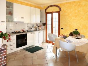 Una cocina con gabinetes blancos y una mesa con sillas. en Holiday Home Casa Marco by Interhome, en Caravonica
