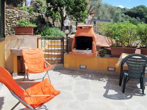 eine Terrasse mit 2 Stühlen und einem Pizzaofen in der Unterkunft Apartment A' Ca' de Alida by Interhome in Ortovero
