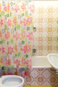 a bathroom with a sink and a shower curtain with flowers at Apartment Euroville-1 by Interhome in Germignaga