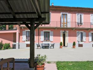 a pink building with benches in front of it at Holiday Home Il Cavaliere by Interhome in Castellero