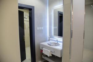 巴勒如拉斯غيوم للفلل الفندقية的一间白色浴室，配有洗手池和镜子。 更多10张照片