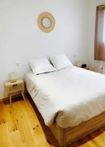 Una cama con sábanas blancas y almohadas en un dormitorio en LE "PETIT GERVAIS" pour un instant parfait !, en Saint-Gervais-les-Bains