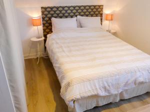 a bedroom with a large bed with two lamps at Apartment Les Christophines by Interhome in Cabourg