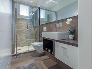 e bagno con servizi igienici, lavandino e doccia. di Apartment Vivaldi - BIB135 by Interhome a Bibione