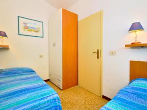 una camera con 2 letti e un armadio di Holiday Home Cassiopea by Interhome a Bibione