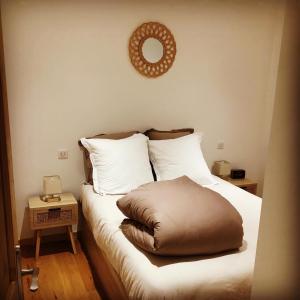 - un lit avec un oreiller brun au dessus dans l'établissement LE "PETIT GERVAIS" pour un instant parfait !, à Saint-Gervais-les-Bains