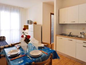 a kitchen with a table with plates and flowers on it at Apartment Pleione-2 by Interhome in Bibione