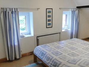 ein Schlafzimmer mit einem Bett und zwei Fenstern in der Unterkunft Apartment Südost by Interhome in Süderneuland Zwei