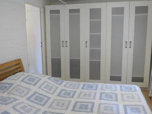 ein Schlafzimmer mit einem Bett und einigen Schränken in der Unterkunft Apartment Südost by Interhome in Süderneuland Zwei