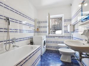 a bathroom with a tub and a toilet and a sink at Apartment Tieja de Gotart-1 by Interhome in Vigo di Fassa