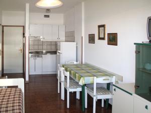 ポルト・サンタ・マルゲリータ・ディ・カオルレにあるApartment La Zattera by Interhomeのキッチン(テーブル、椅子、冷蔵庫付)