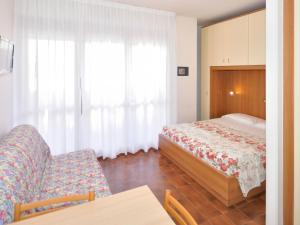 um quarto com uma cama, uma cadeira e uma mesa em Apartment Cavallino by Interhome em Bibione