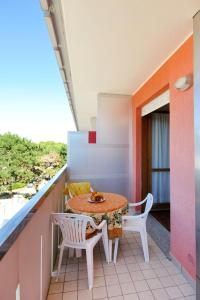 a small balcony with a table and two chairs at Apartment Cavallino - BIB116 by Interhome in Bibione