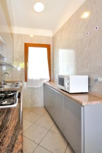 una cocina con microondas blanco en una encimera en Apartment Villaggio Delfino-2 by Interhome, en Bibione