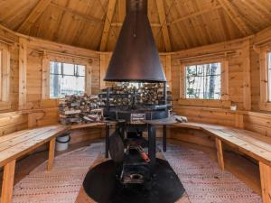 a kitchen with a stove in a wooden cabin at Holiday Home Puolen hehtaarin metsä by Interhome in Haapaniemi