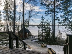 a wooden stairs leading to a gazebo on a lake at Holiday Home Puolen hehtaarin metsä by Interhome in Haapaniemi
