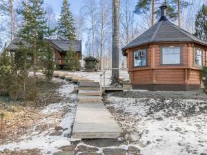 a cabin in the woods with a wooden walkway at Holiday Home Puolen hehtaarin metsä by Interhome in Haapaniemi
