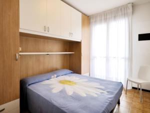 ein Schlafzimmer mit einem blauen Bett mit einer Blume darauf in der Unterkunft Apartment Pleione-1 by Interhome in Bibione