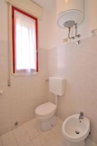 bagno bianco con servizi igienici e lavandino di Apartment Gaia by Interhome a Bibione