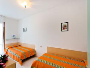 Dos camas en una habitación con paredes blancas. en Holiday Home Villaggio Maja by Interhome, en Bibione