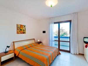 Un dormitorio con una cama y una puerta corrediza de vidrio. en Holiday Home Villaggio Maja by Interhome, en Bibione