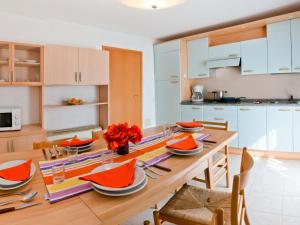 Una cocina y un comedor con mesa y sillas de madera. en Holiday Home Villaggio Maja by Interhome, en Bibione