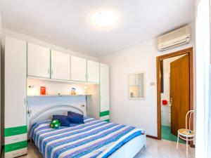 a bedroom with a bed with a blue and white striped blanket at Holiday Home Super Dinky - BIB287 by Interhome in Bibione +14 photos