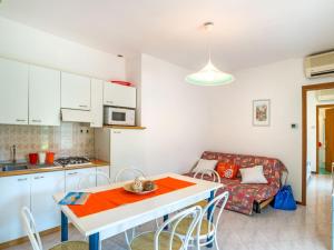 una cucina e un soggiorno con tavolo e divano di Holiday Home Super Dinky - BIB287 by Interhome a Bibione