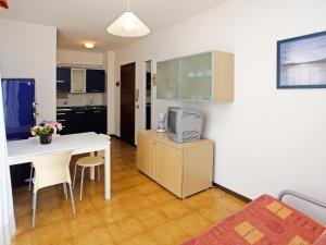 ビビオーネにあるApartment Villaggio Serenissima-2 by Interhomeのキッチン、テーブル、テレビが備わる客室です。