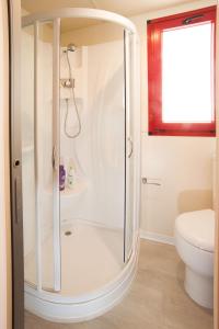 ドゥナ・ヴェルデにあるHoliday Home Villaggio San Francesco 5-3 by Interhomeのバスルーム(ガラスドア付きのシャワー付)